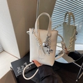 Elegante borsa a secchiello bianco crema con ciondolo a cane palloncino e dettagli intrecciati - Bianco Crema Con Ciondolo