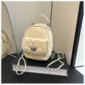 Detailed view of quilted cream mini backpack with silver chain strap and metal clasp - Yellow