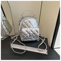 Close-up of silver quilted mini backpack with metal chain strap and twist-lock detail - Silver