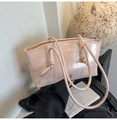 Détail du cabas en cuir verni rose nude avec poignées à nœuds et décorations métalliques - Rose