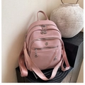Detail of soft pink leather backpack featuring silver zippers and a woven wide shoulder strap - Pink