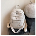 Detailed view of cream PU leather backpack with silver zippers and geometric straps - White