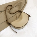 Aprikosenfarbene Crescent-Umhängetasche aus Leder mit braunem Rand und Goldbeschlägen - Khaki