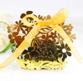 Close-up of golden laser-cut floral favor box with yellow organza ribbon and bow - Reflective Gold