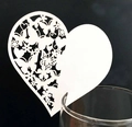 Laser cut white heart shaped place card with butterfly pattern on a glass rim - White