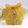 Macro detail of laser-cut floral candy box in gold cardstock with ribbon bow - Gold