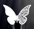 Close-up of laser-cut white paper butterfly place card with intricate rose patterns - White