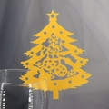 Close-up of golden laser-cut Christmas tree place card on the edge of a glass - Gold