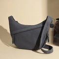 Macro detail of dark grey corduroy fabric texture and crescent shape on a crossbody bag - Gray