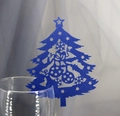 Macro shot of blue laser-cut Christmas tree place card on a wine glass rim - Sapphire Blue