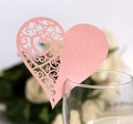 Close-up of pink laser-cut heart glass card with vine pattern for wedding decor - Pink