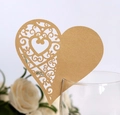 Détail du marque-place coeur doré découpé au laser sur verre avec fond de roses blanches - Beige Or