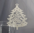 Close-up of laser-cut silver glitter Christmas tree place card on a wine glass rim - Silver