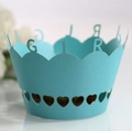Macro detail of sky blue laser-cut cupcake wrapper with GIRL text and heart patterns - Turquoise Blue