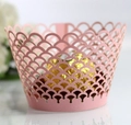 Close-up of pink laser-cut fish scale cupcake wrapper with a gold foil chocolate - Pink