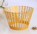 Close-up of golden laser-cut cupcake wrapper with elegant geometric hollow patterns - Gold