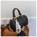 Close-up of black pebbled leather Boston bag featuring a colorful charm and gold hardware - Black with Pendant