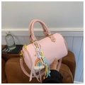 Détail du sac Boston rose en cuir grainé avec un pendentif décoratif arc-en-ciel - Rose avec pendentif