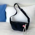 Black crescent crossbody bag in canvas fabric featuring a wide adjustable strap and heart charm - Black