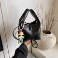 Minimalist black leather bucket handbag with top handle and pearl doll charm detail - Black with Pendant