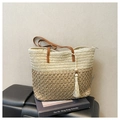 Detalle del bolso tote de paja tejida con correas de cuero y borla de algodón blanca - Talla única / Beige y Caqui