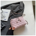 Close-up of pink quilted crossbody bag with silver flower clasp and woven chain strap - L / Pink