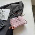 Pink quilted leather crossbody bag with chain strap and flower charm on grey blazer - Large / Pink