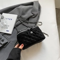 Elegant black quilted chain bag with a silver flower zipper pull on a grey suit blazer - Large / Black