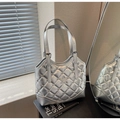 Silberne Stepptasche mit Sternenmotiv und Nieten in moderner Innenraumkulisse - Silber