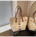 Detail of a canvas tote bag with blue telm letters and brown leather handles - Off White