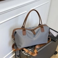 Large gray travel tote bag with brown leather handles placed on silver luggage - M / Gray