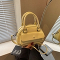 Chic cream yellow bowling bag with dual handles and adjustable strap for summer fashion - Yellow