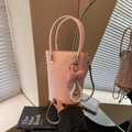 Roze PU-leren emmertas met zilveren ketting en parelmoer strikhanger in een sfeervolle setting - Met Hanger / Roze