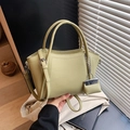 Chic light green lychee leather bucket bag with top handles and mini charm pendant - Green