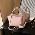Pink bucket bag with lychee grain texture, circular handles and mini pouch charm - Pink