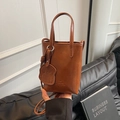 Mini caramel brown PU leather bucket bag with puppy charm and crossbody strap - Brown