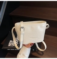 Dettaglio borsa a secchiello bianca intrecciata con logo MUONJIN su scale in legno - Bianco