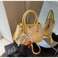 Detail of cream and yellow bucket bag with lychee texture and pearl lace bow charm - Yellow
