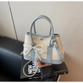 Détail du sac seau bleu et blanc avec nœud en perles et accents de dentelle fine - Bleu