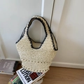 Detalle de la textura de paja tejida y el ribete de ganchillo negro del gran bolso playero - Beige