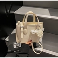 Detalle de mini bolso blanco crema con colgante de corazón de perlas y lazo de encaje - Blanco Roto