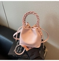 Detalle del bolso bombonera de cuero rosa con asa trenzada y cierre de cordón - Rosa