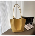 Dettaglio macro della borsa tote gialla a coccodrillo accanto a un laptop - Giallo