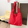 Detail der roten Nylon-Einkaufstasche mit Rüschenriemen und silbernen Nieten-Verzierungen - Rot