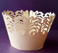 Detail of laser-cut cupcake wrappers with elegant cream floral lace crown pattern - Champagne