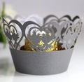 Macro detail of laser-cut silver pearl paper cupcake wrapper with heart and bird motifs - Silver Gray