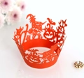 Macro view of red laser-cut Halloween cupcake wrapper featuring witch and pumpkin motifs - Orange Red