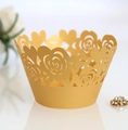 Close-up of golden laser-cut cupcake wrapper with intricate rose and heart patterns - Gold