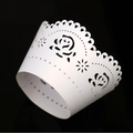 Laser-cut white paper cupcake wrappers with intricate floral and heart lace patterns - White