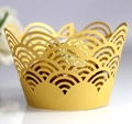 Macro shot of gold laser-cut cupcake wrapper featuring elegant wave patterns - Gold
